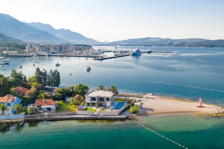 The waterfront from over the bay: houses, shoreline, and the ridge on the far shore.
