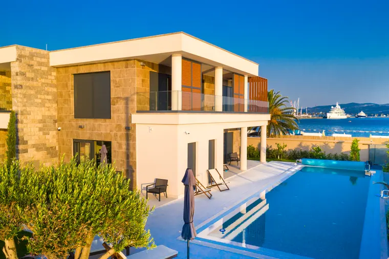 The pool terrace and pergola, with moored yachts in the distance.