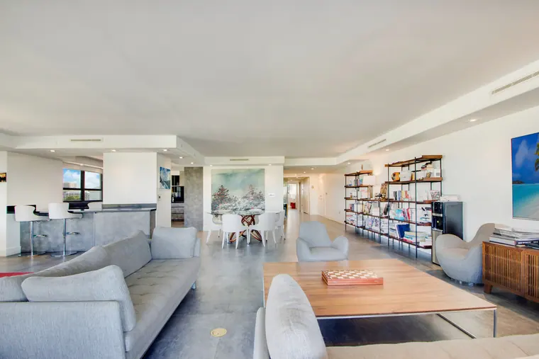 The library end of the living room, shelving carried full height beside the seating.