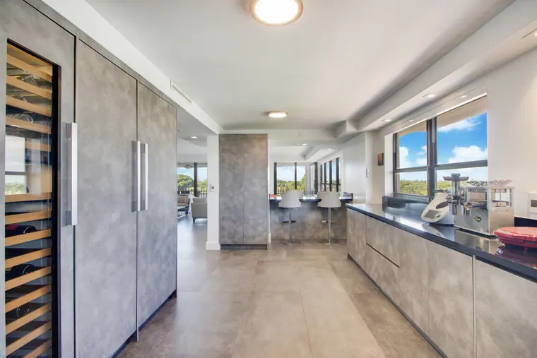 The kitchen from the far end, tall storage and wine racking beside the counter run.