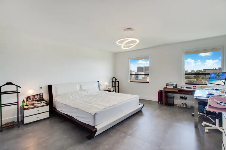 A bedroom with a desk beneath the window and fitted storage.